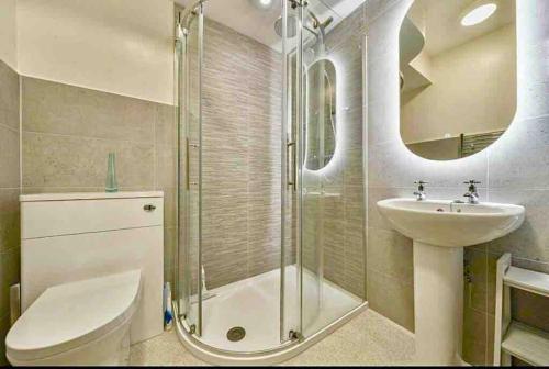 a bathroom with a shower and a sink and a toilet at A charming luxury apartment! in Portinscale