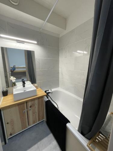une salle de bain avec une baignoire blanche et un lavabo dans l'établissement Studio cosy 1700, à Puy-Saint-Vincent