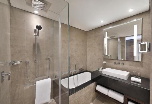 a bathroom with a glass shower and a sink at Hilton Riyadh Hotel & Residences in Riyadh