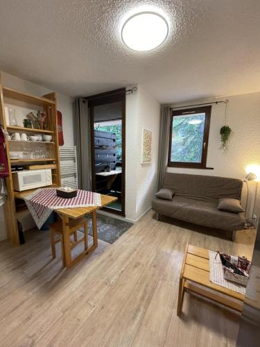 un salon avec une table et un canapé dans l'établissement Studio cosy 1700, à Puy-Saint-Vincent