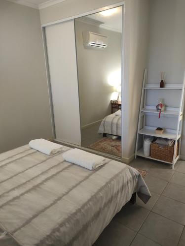 1 dormitorio con espejo grande junto a la cama en South Hedland Accomodation - Nice - Tidy - Secure en South Hedland