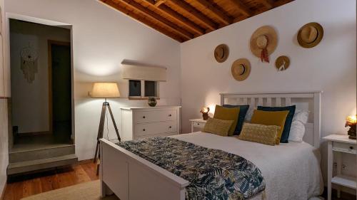 ein Schlafzimmer mit einem großen Bett mit gelben und blauen Kissen in der Unterkunft Quinta das Almas in São Roque do Pico