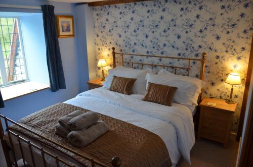 a bedroom with a bed with towels on it at Hafannedd in Corwen
