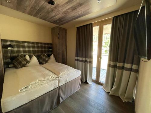 a bedroom with a bed and a large window at Mountain Spa Residences in Sankt Anton am Arlberg
