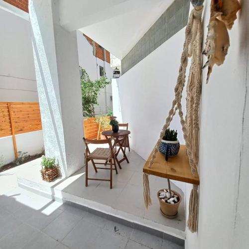 a porch with a swing and a table and chairs at New studio in the city! in Kos Town