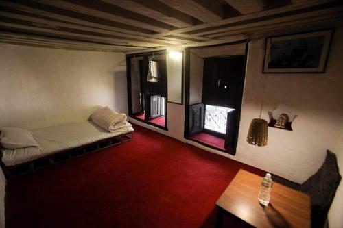 Zimmer mit einem Bett und einem roten Teppich in der Unterkunft Traditional Newari Homestay in Pātan