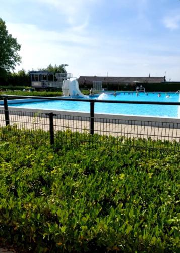 a large swimming pool with a water slide at Vakantiechalet Jonagold 4 personen in Hengstdijk