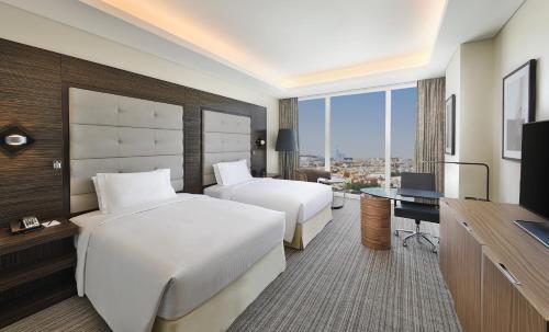 a hotel room with two beds and a desk at Hilton Riyadh Hotel & Residences in Riyadh