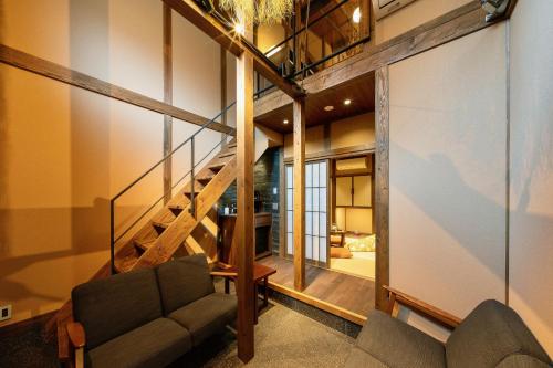 a living room with a staircase and a couch at Kagabi Machiya House in Kanazawa