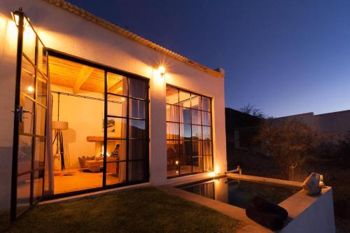 a house with a swimming pool at night at De Kombuys in Oudtshoorn