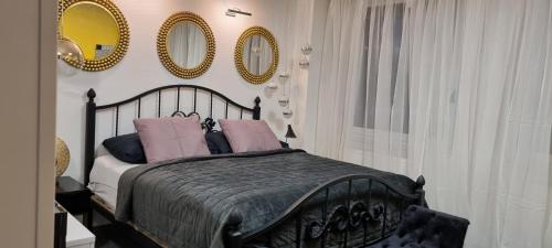 una camera da letto con letto dotato di cuscini e specchi rosa di Sluníčkový apartmán A9 v Chomutově a Chomutov