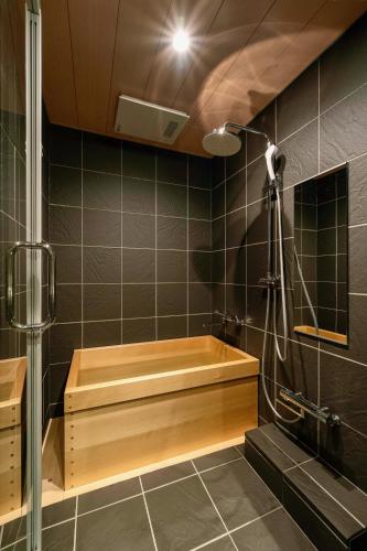 a bathroom with a wooden tub and a shower at Kagabi Machiya House in Kanazawa