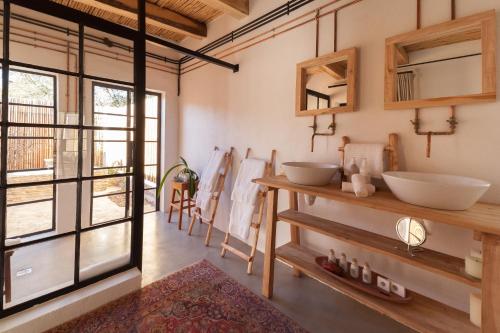 a bathroom with two sinks and a large window at De Kombuys in Oudtshoorn