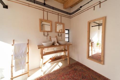a room with a mirror and a table with bowls on it at De Kombuys in Oudtshoorn