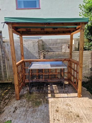 a wooden pavilion with a picnic table under it at Daron Large Country Cottage in Llansannan