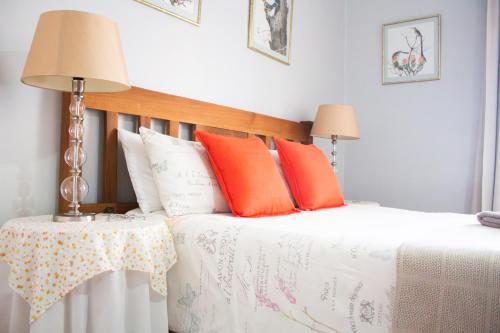 a bedroom with a bed with orange and white pillows at De Oude Yotclub in Oudtshoorn