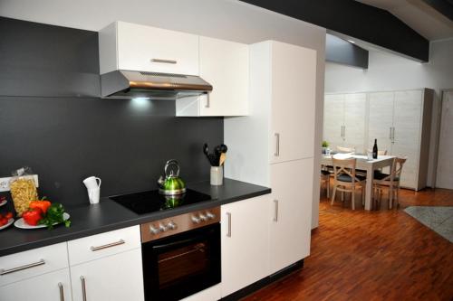 a kitchen with white cabinets and a black counter top at Rooftop Regensburg in Regensburg