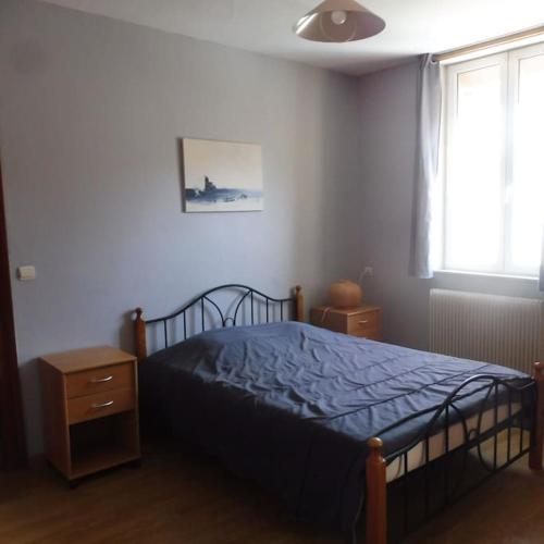 une chambre avec un lit avec une couette bleue et une fenêtre dans l'établissement Appartement spacieux dans rue calme, à Wimereux