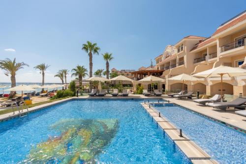 - une piscine dans un complexe avec des chaises et des parasols dans l'établissement Safir Marsa Matrouh Resort, à Marsa Matruh