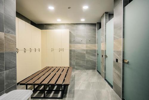 eine ebenerdige Dusche mit einer Holzbank im Bad in der Unterkunft Akhaltsikhe Inn in Achalziche