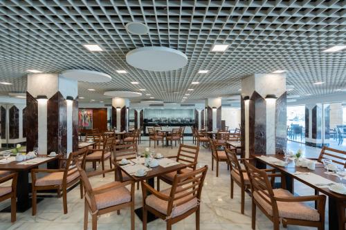 a dining room with wooden tables and chairs at Safir Marsa Matrouh Resort in Marsa Matruh