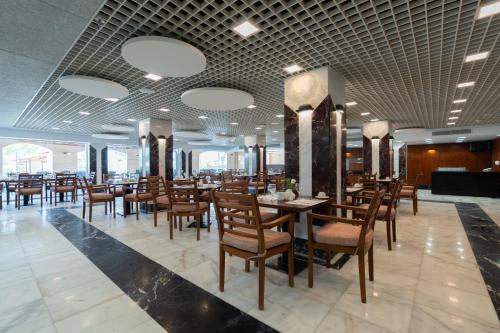 a dining room with tables and chairs in a restaurant at Safir Marsa Matrouh Resort in Marsa Matruh