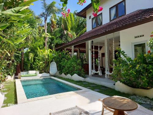 a house with a swimming pool in front of a house at Medori Villa Seminyak in Seminyak