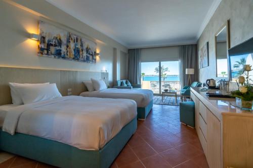 a hotel room with two beds and a living room at Safir Marsa Matrouh Resort in Marsa Matruh
