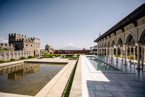 a view of a building with a pool and a castle at Akhaltsikhe Inn in Akhaltsikhe