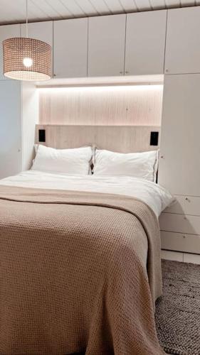 - une chambre avec un grand lit et une couverture brune dans l'établissement Beautiful Villa by the sea, à Porvoo