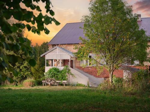 una casa con un tavolo e una panchina di fronte ad essa di Folwark Rafałówka by Renters a Zabłudów