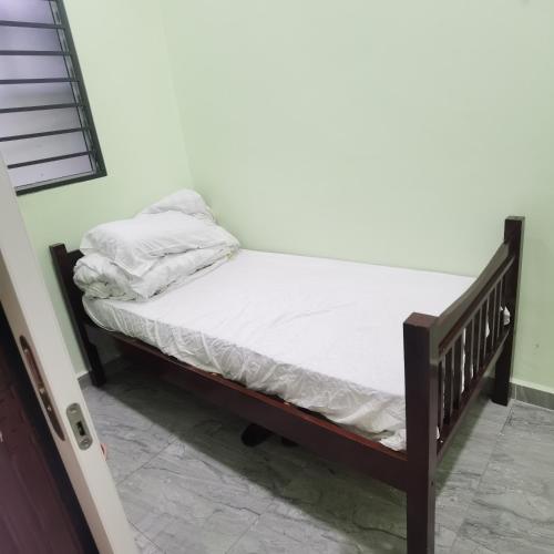 ein kleines Bett in einem Zimmer mit einer weißen Matratze in der Unterkunft 2号房有厕所厨房冰箱洗衣机 in Kuala Lumpur