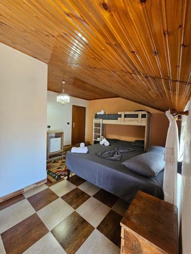 - une chambre avec un grand lit et un plafond en bois dans l'établissement Voga Guesthouse, à Krujë