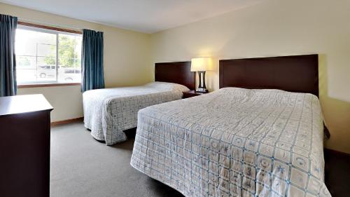 ein Hotelzimmer mit 2 Betten und einem Fenster in der Unterkunft Put-in-Bay Poolview Condo #4 in Put-in-Bay