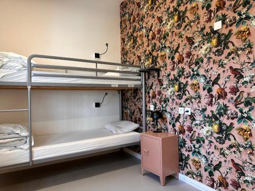 1 dormitorio con literas y papel pintado con motivos florales en Auberge de Jeunesse HI Lille, en Lille