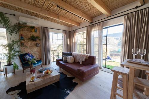 a living room with a couch and a table at De Kombuys in Oudtshoorn