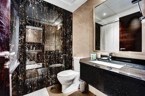 a bathroom with a toilet and a sink and a mirror at Fantastic Spacious Apartment with Panoramic Views in Dubai