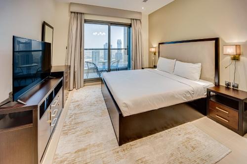 a bedroom with a bed and a flat screen tv at Fantastic Spacious Apartment with Panoramic Views in Dubai