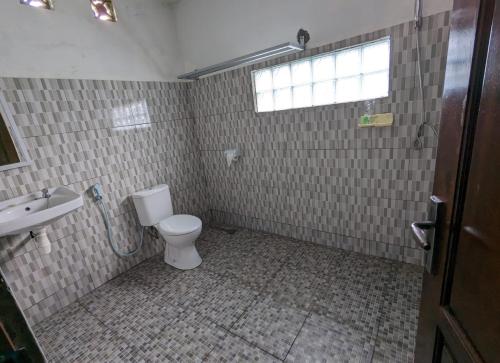 a bathroom with a toilet and a sink at Mushtinal Guest House in Ende
