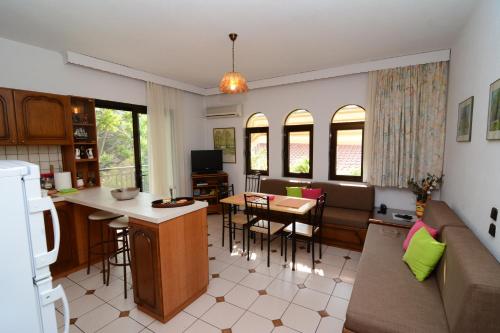 cocina y sala de estar con sofá y mesa en Villa Kirki, en Nea Iraklitsa