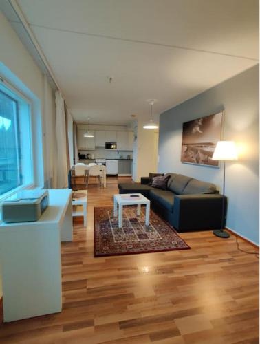 uma sala de estar com um sofá e uma mesa em Kotimaailma - Saunallinen kolmio lähellä lentokenttää em Vantaa