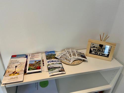 a table with books and pictures on it at Green Sun - a cozy apartment close to the airport in Opfikon