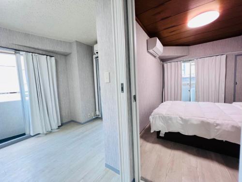 a bedroom with a bed and a large window at The Kojima in Tokyo