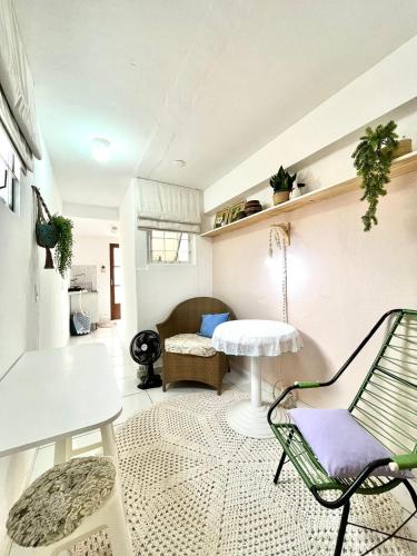 uma sala de estar com uma cadeira e uma mesa em Kitnet vila adyana em São José dos Campos