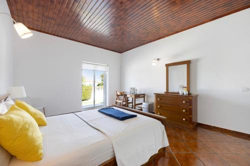 a bedroom with a bed and a dresser and a mirror at Villa Oliveira in Aljezur