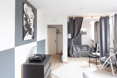 a living room with a black cabinet and a bedroom at - Nice New York apartment in the heart of Duisburg - Betten & Sofa - 5 Mins Central Station Hbf - Big TV & WiFi - in Duisburg