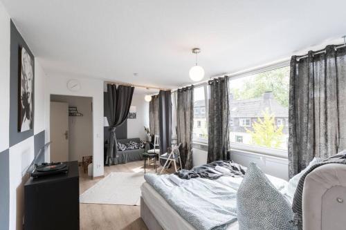 a bedroom with a bed and a large window at - Nice New York apartment in the heart of Duisburg - Betten & Sofa - 5 Mins Central Station Hbf - Big TV & WiFi - in Duisburg