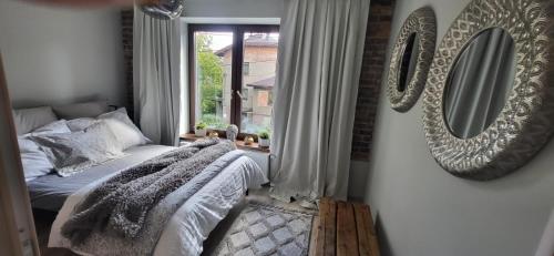 a bedroom with a bed and a mirror on the wall at Urocze Studio 7 z parkingiem in Katowice