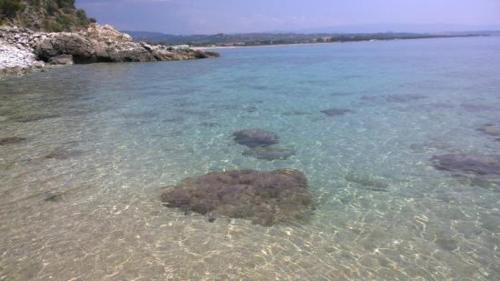 a body of water with rocks in the water at Casa Cobalto - Lascio tutto vivo a Copanello in Copanello
