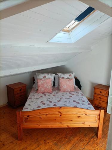 - une chambre mansardée avec un lit en bois dans l'établissement T2 Intra-Murros 